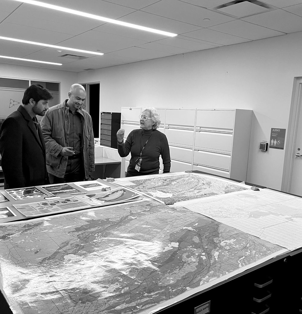 Una especialista explica mapas geológicos a participantes de una visita técnica