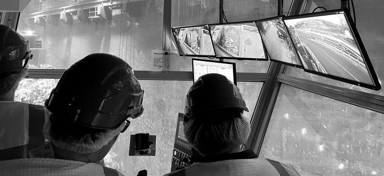 Equipo con cascos monitoreando operaciones desde una sala de control